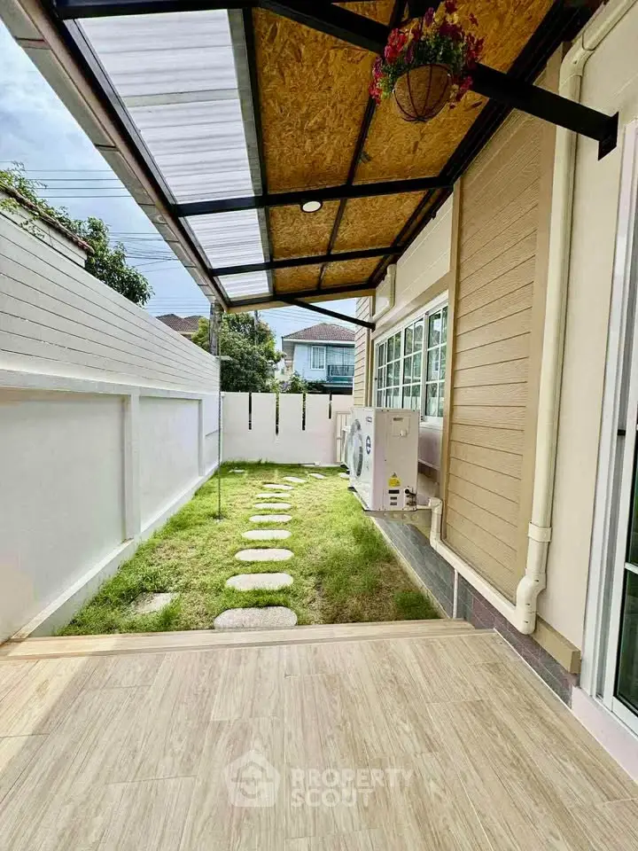 Charming backyard with covered patio and lush green lawn, perfect for outdoor relaxation.