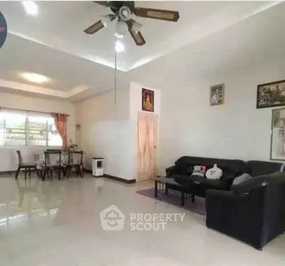 Spacious living room with modern ceiling fan and cozy seating area