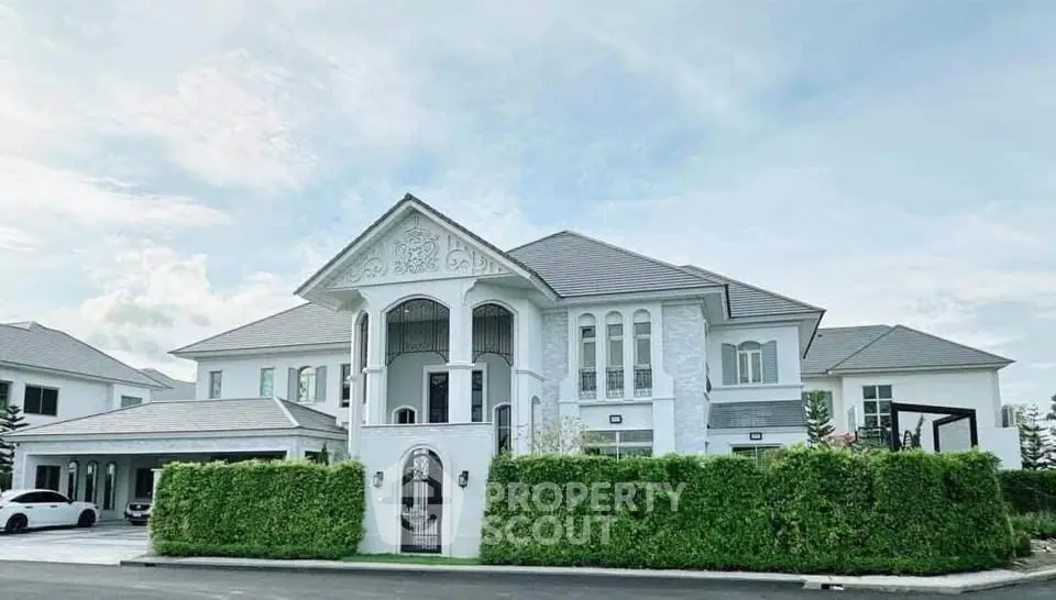 Luxurious white mansion with elegant architecture and lush greenery, perfect for upscale living.