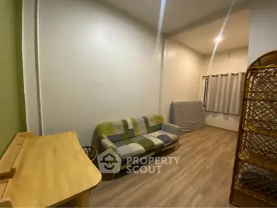 Cozy living room with modern sofa and wooden flooring, perfect for relaxation.
