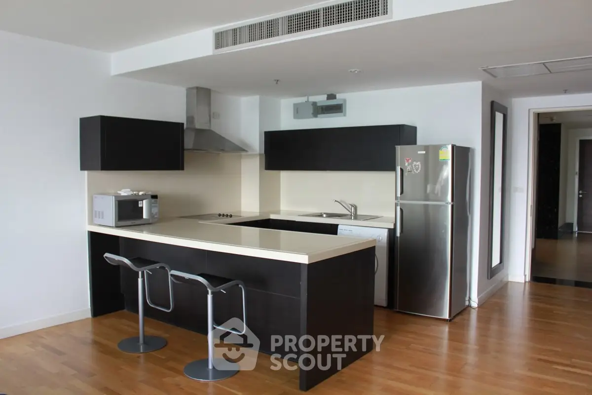 Modern kitchen with sleek black cabinets and stainless steel appliances in open layout