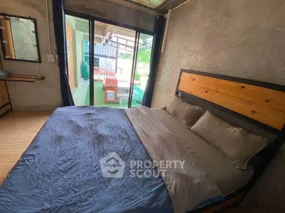 Cozy bedroom with modern decor and large window overlooking a private balcony.