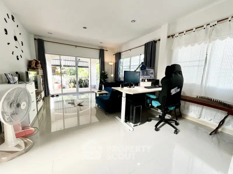 Spacious modern living room with home office setup and garden view