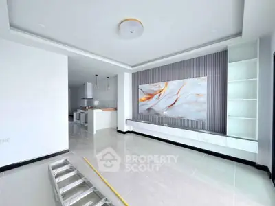 Spacious modern living room with elegant marble accents and open kitchen layout.