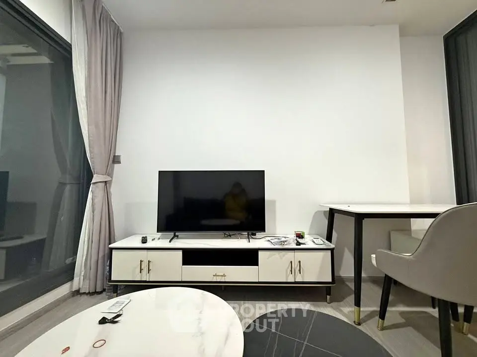 Modern living room with sleek TV stand and large windows, perfect for urban living.