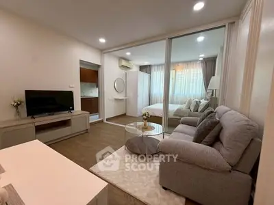Modern studio apartment with cozy living area and bedroom, featuring elegant decor and natural light.