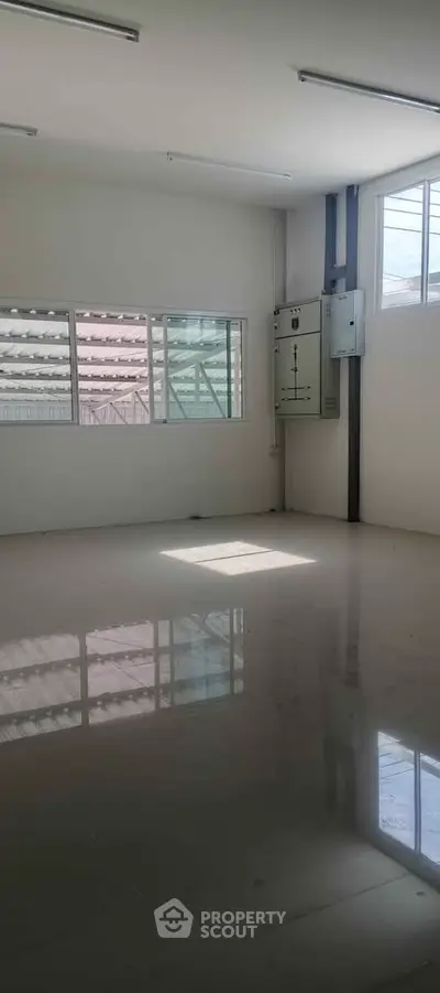 Spacious empty room with large windows and glossy tiled floor, ideal for customization.