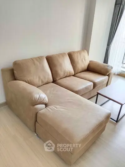 Spacious living room with modern beige sectional sofa and natural light