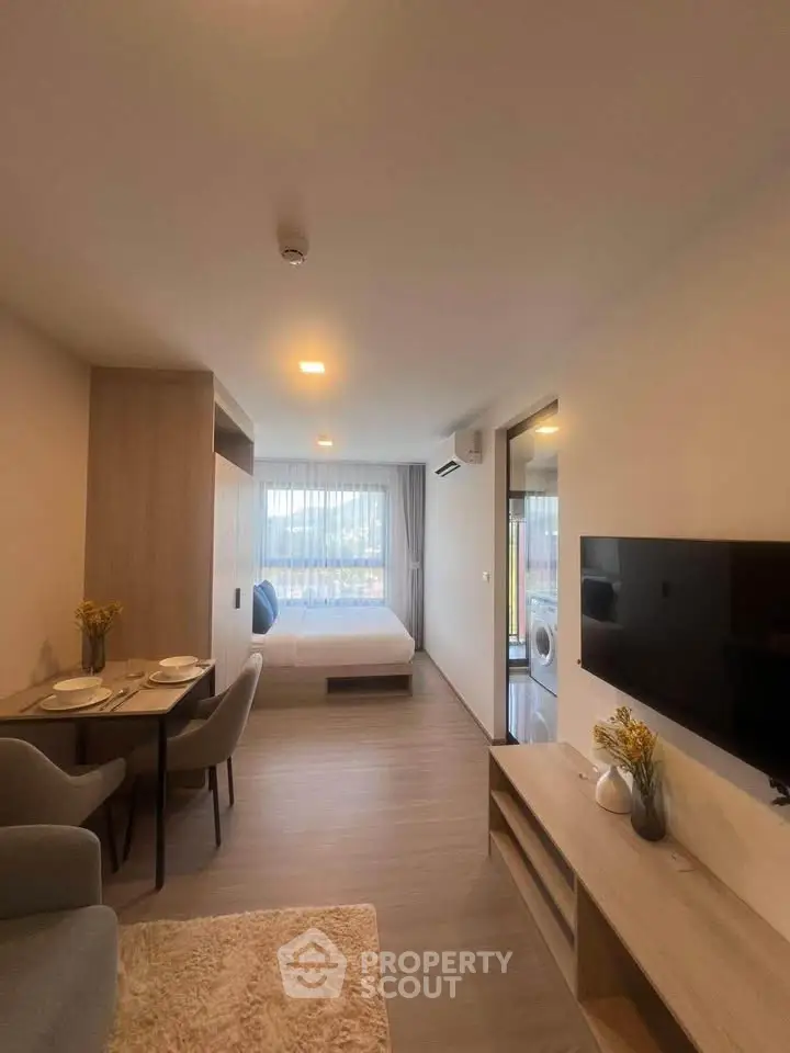 Modern studio apartment with cozy living area and bedroom, featuring stylish decor and natural light.