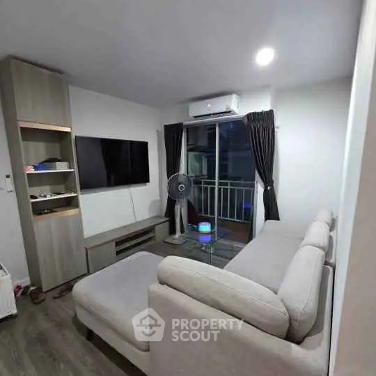 Modern living room with sleek furniture and balcony view, perfect for urban living.