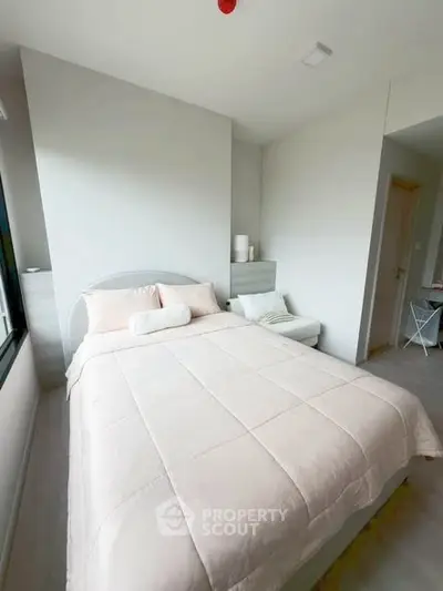 Cozy bedroom with modern decor and natural light, perfect for relaxation and comfort.