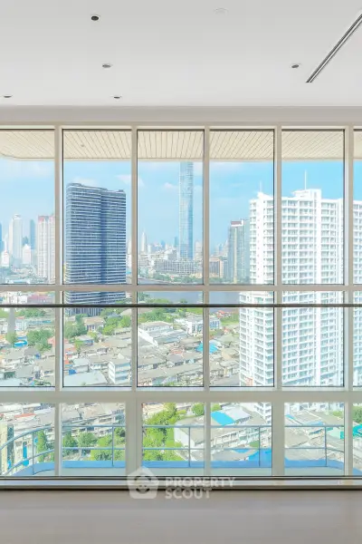 Stunning high-rise apartment with panoramic city skyline views through floor-to-ceiling windows.
