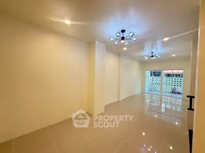 Spacious modern living room with elegant lighting and glossy tiled floors.