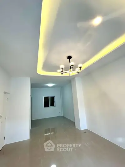 Spacious modern living room with elegant ceiling lighting and glossy tiled floors.