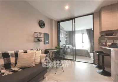 Modern open-plan living room with cozy decor and adjacent bedroom view.