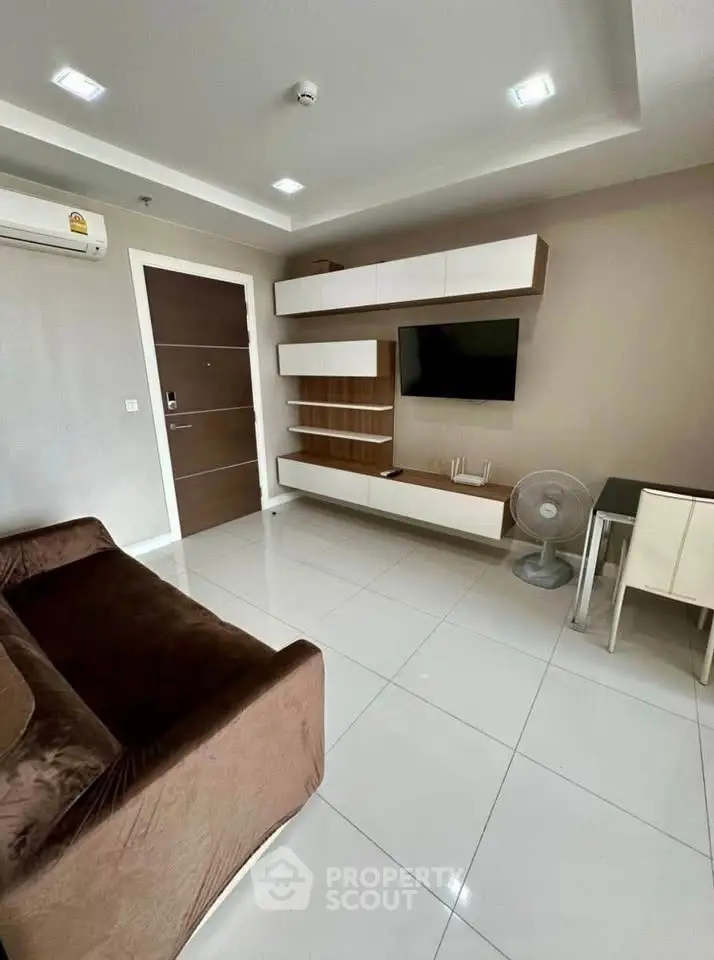 Modern living room with sleek furniture and wall-mounted TV in a stylish apartment.
