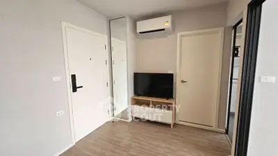 Modern apartment interior with air conditioning and sleek TV setup.