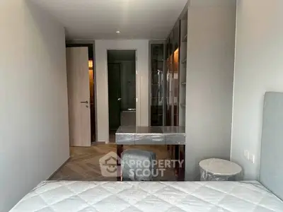 Modern bedroom with sleek furniture and neutral tones, featuring a stylish vanity and cozy ambiance.