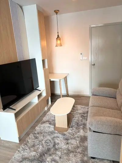 Modern living room with cozy sofa, stylish TV stand, and elegant lighting in a chic apartment.