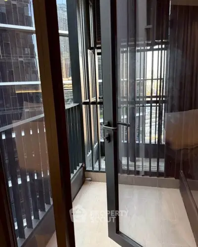 Modern apartment balcony with city view and sleek glass door