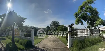 Spacious garden entrance with lush greenery and clear blue sky