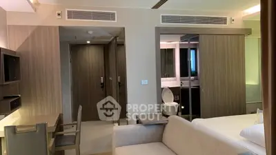 Modern hotel room with sleek design, featuring a cozy bed, stylish bathroom, and functional workspace.