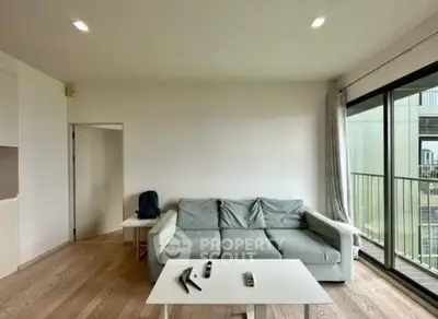 Modern living room with sleek sofa and balcony view in contemporary apartment.
