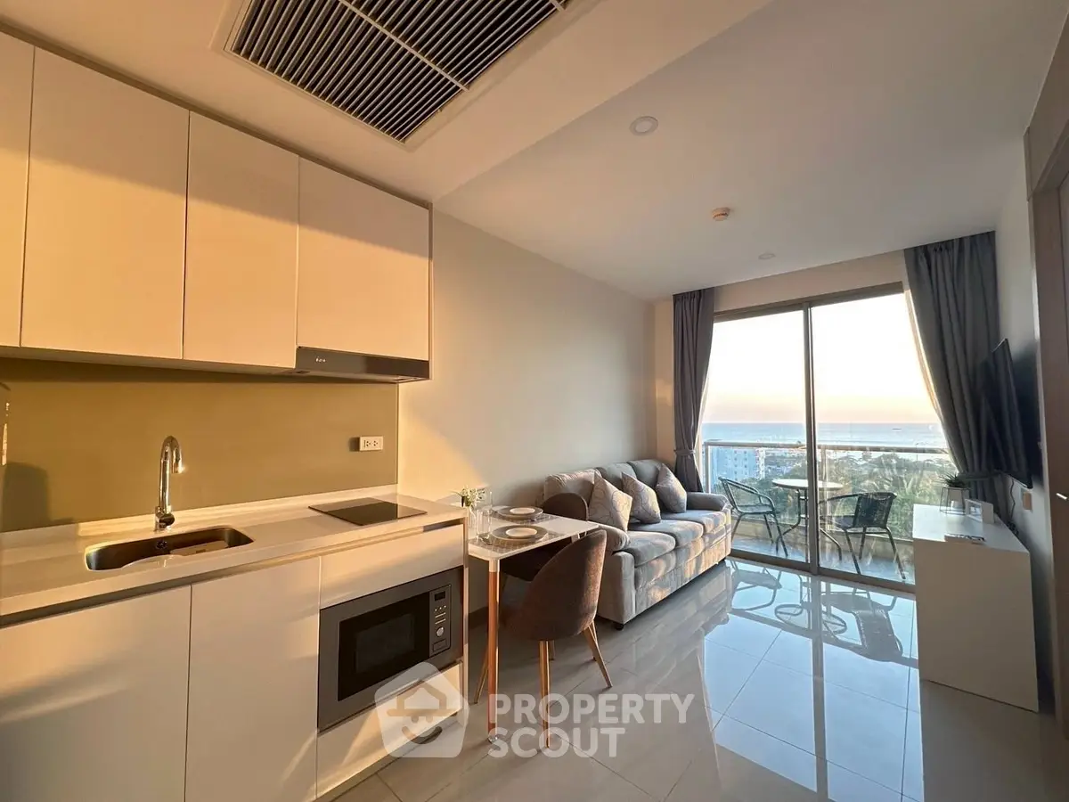 Modern open-plan living room with kitchen and stunning ocean view balcony