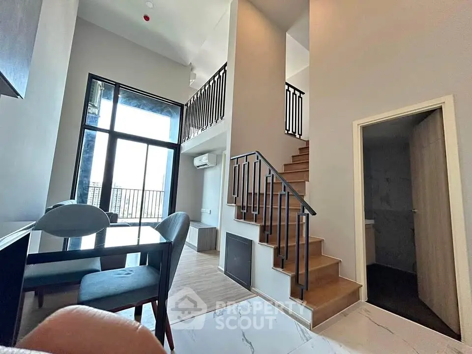 Modern duplex interior with high ceilings and stylish staircase