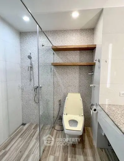 Modern bathroom with glass shower and wooden shelves