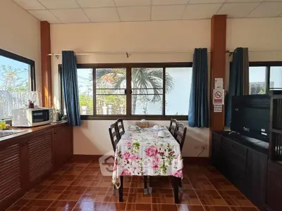 Charming dining area with floral tablecloth and natural light, perfect for cozy meals.
