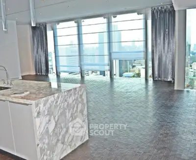 Luxurious open-plan living room with marble island and stunning city view.