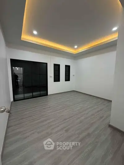 Spacious modern living room with elegant lighting and sleek flooring, perfect for contemporary living.