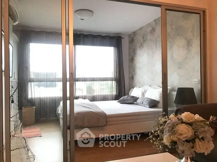 Modern bedroom with large window and elegant decor, perfect for relaxation.