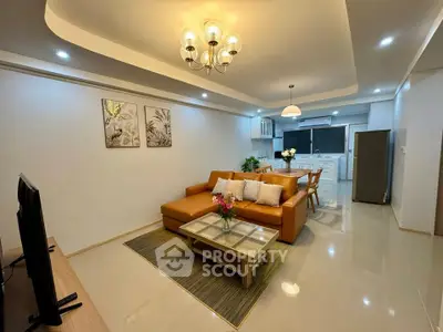 Spacious modern living room with open kitchen, stylish decor, and elegant lighting in a contemporary apartment.