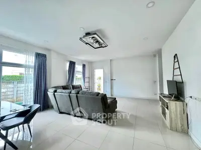 Spacious modern living room with sleek furniture and large windows for natural light.