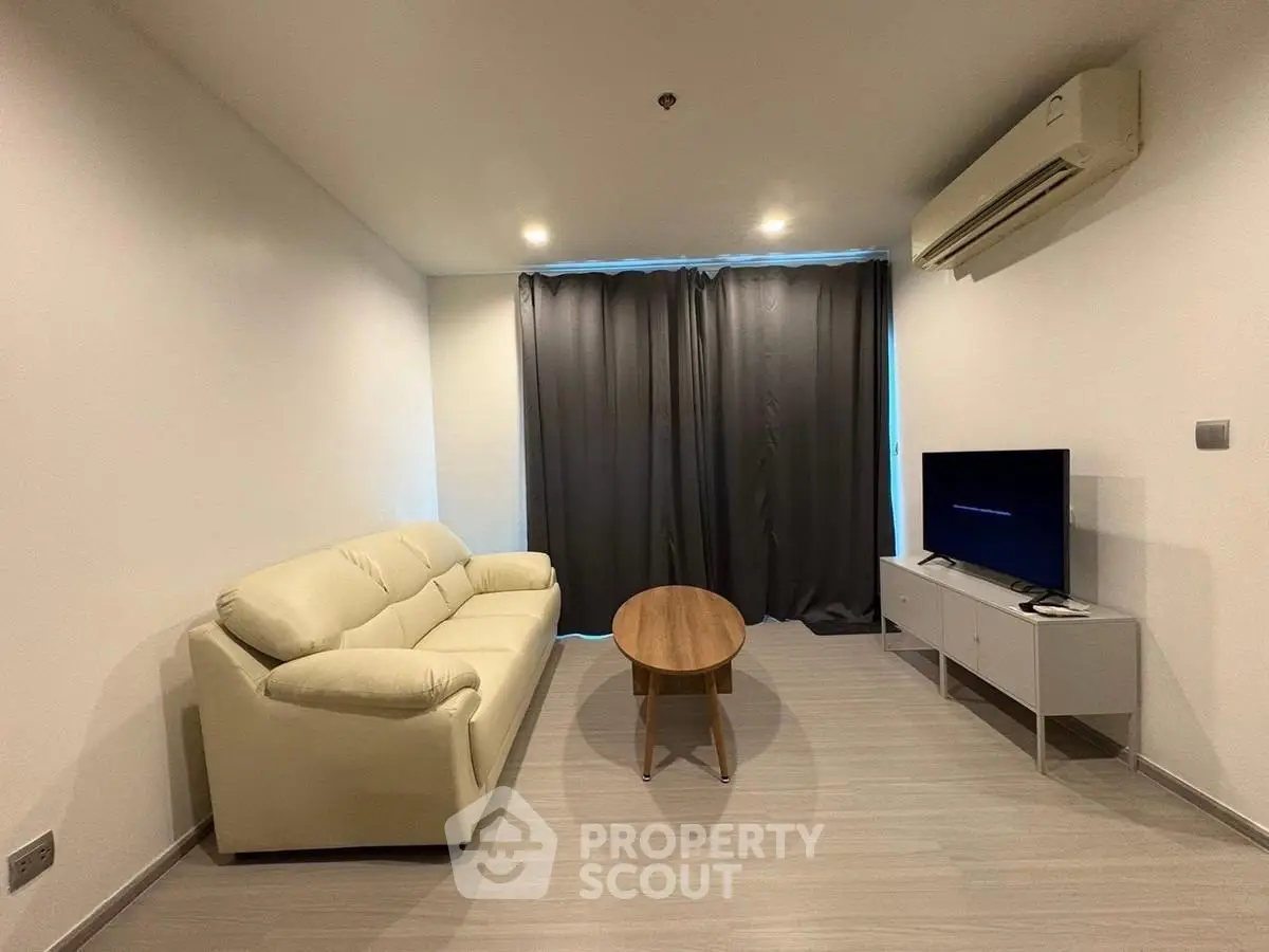 Modern living room with sleek furniture and air conditioning in a minimalist apartment.