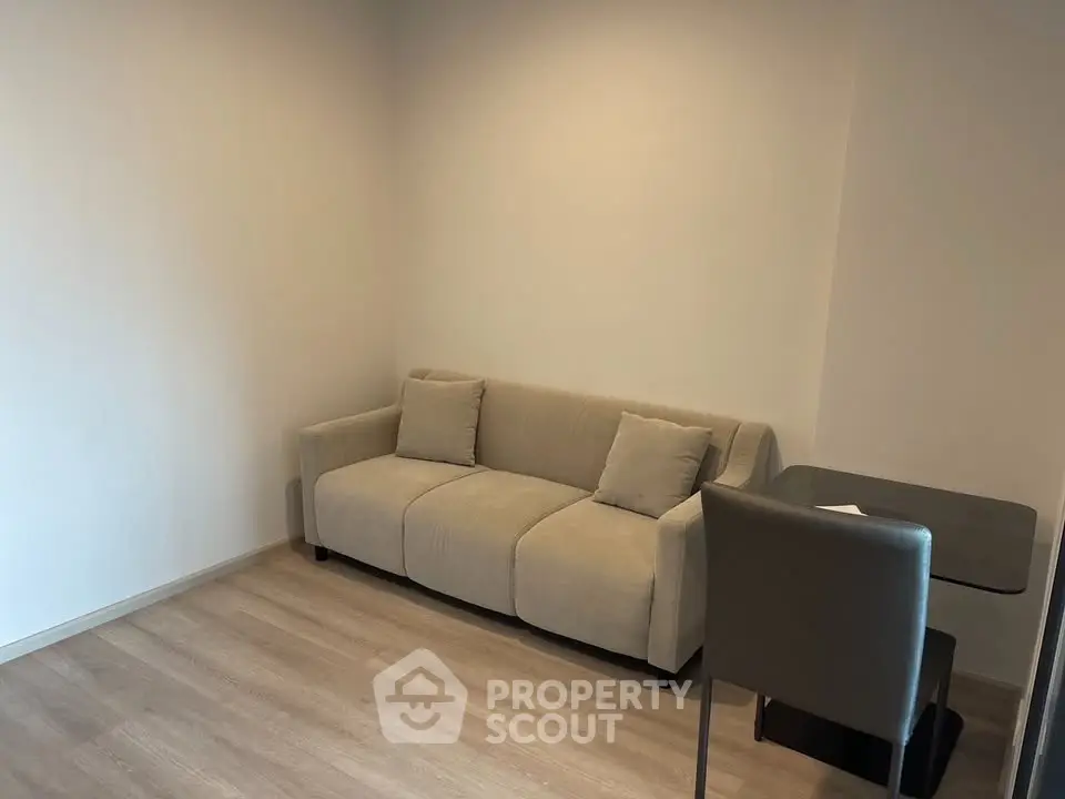 Minimalist living room with beige sofa and small table, perfect for cozy relaxation.