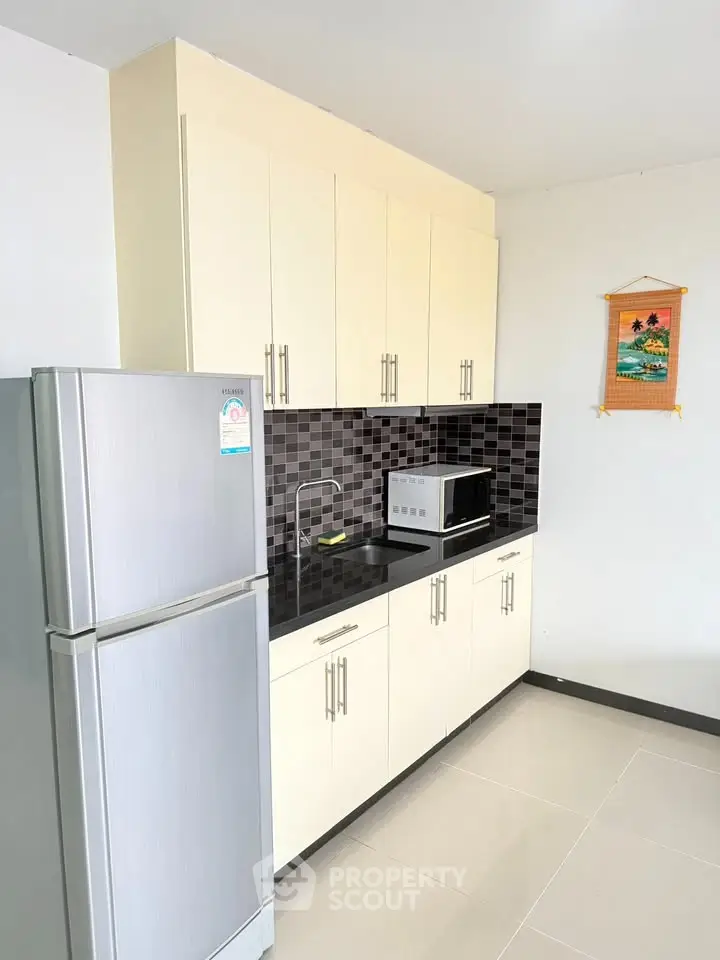 Modern kitchen with sleek cabinetry and appliances in a stylish apartment.