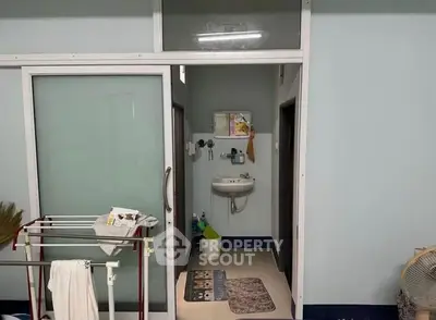 Compact bathroom with sliding glass door and wall-mounted sink