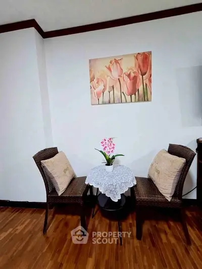 Cozy corner with wicker chairs and floral decor in a stylish living room.