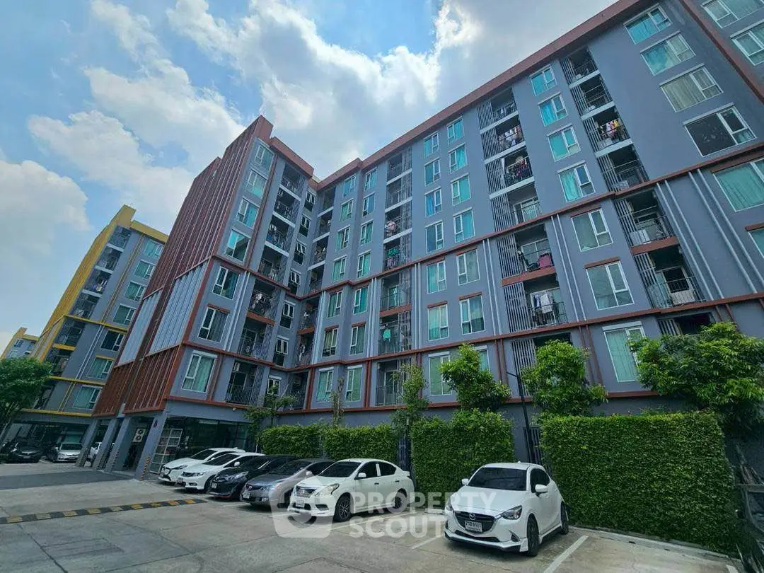 Modern residential building with ample parking and lush greenery