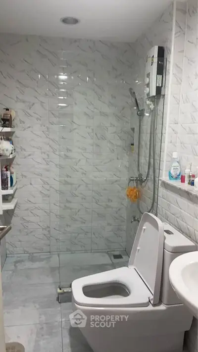 Modern bathroom with sleek tiles and shower area in a contemporary home.