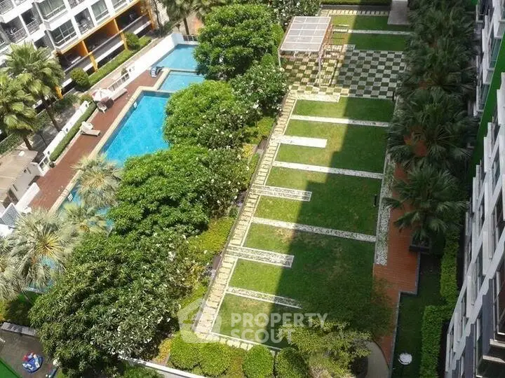 Luxurious residential complex with lush garden and inviting swimming pool view.