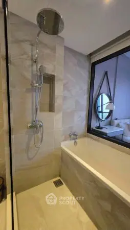 Modern bathroom with sleek shower and bathtub, featuring elegant tile design and large window.