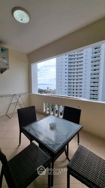 Spacious balcony with ocean view in modern high-rise apartment.