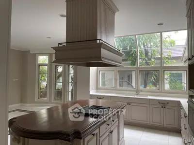 Spacious kitchen with island and large windows offering natural light.