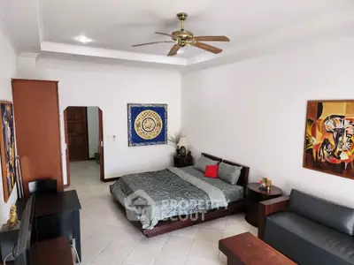 Spacious bedroom with modern decor and ceiling fan in elegant home.