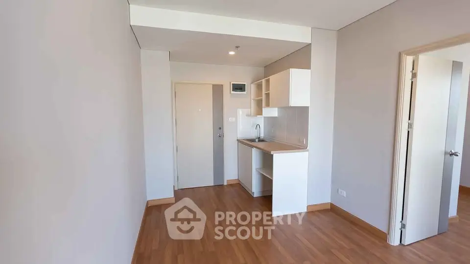 Modern minimalist kitchen with wooden flooring and sleek cabinetry