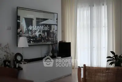 Stylish living room with modern decor and large TV, perfect for relaxation.